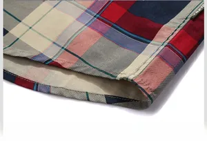 Close-up of multicolor plaid shirt hem with double stitching and fashion woven label