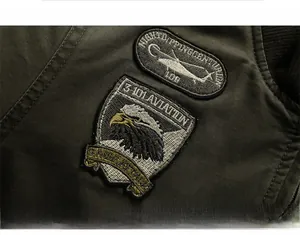 Detail of heavy cotton military jacket featuring embroidered helicopter and eagle patches