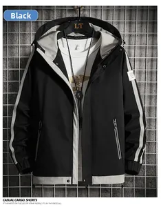 Detail of black hooded jacket with contrast sleeve taping and industrial background