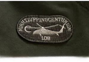 Macro detail of high-density helicopter embroidery on a heavy-duty green jacket