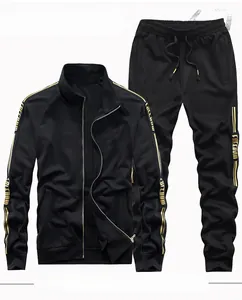 Flat lay of men's black tracksuit with gold stripes and Freedom lettering details