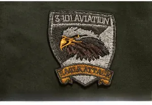 Detail of high-density eagle military embroidery on a dark green men's jacket