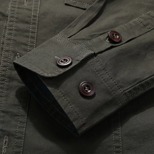 Detail of dark olive military style cotton shirt sleeve with classic buttons and stitching
