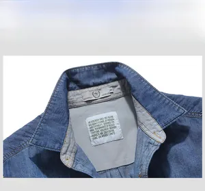 Close-up of denim shirt collar with woven brand labels and gray inner lining