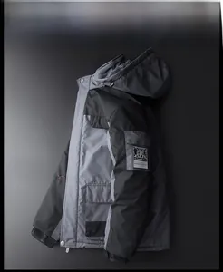 Detail of grey and black outdoor parka featuring the athletic badge on the sleeve