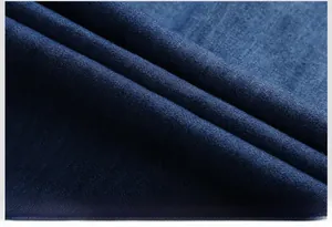 Macro shot of dark blue denim twill fabric texture with soft folds on a men's shirt