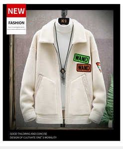 Detailed view of cream fleece jacket featuring colorful WAND letter patches and zipper