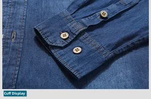 Detailed close-up of blue denim shirt cuff with orange stitching and vintage wooden buttons