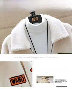 Detail of faux shearling jacket featuring vibrant WAND letter patches on sleeve