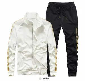 Detail of white track jacket and black joggers with gold side stripes and Freedom text