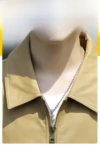 Detail of a khaki cotton jacket featuring a premium bronze metal zipper and sleek collar
