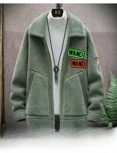 Close-up of sage green fleece jacket featuring large lapel and vibrant letter patch detail