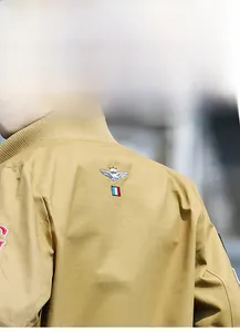 Detail of military khaki jacket with intricate gold crown and wing embroidery on the back