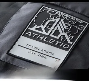 Macro detail of high-quality embossed rubber logo on outdoor hiking jacket sleeve