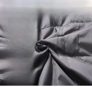 Detailed macro view of quilted grey fabric texture for men's winter business jacket