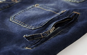 Detailed view of dark blue denim jacket pockets with sturdy metal zipper and stitching