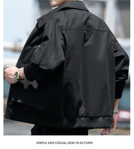 Detail view of black utility jacket featuring side sleeve pocket and ribbed cuffs