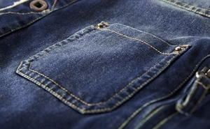 Detail of blue denim jacket showing double yellow stitching and white fleece lining