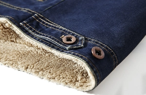 Detail of warm brown sherpa fleece lining and contrast yellow stitching on denim jacket