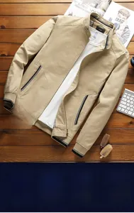 Flat lay of khaki men's stand collar washed cotton jacket on dark wooden floor