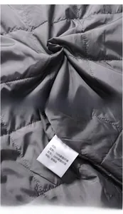 Detailed close-up of dark grey quilted polyester lining and interior fabric quality