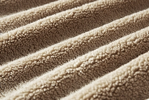 Macro detail of thick beige sherpa fleece lining on a winter denim jacket for warmth