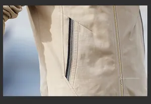 Close-up of a beige jacket pocket featuring striped ribbon trim and a gold zipper