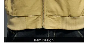 Detail view of khaki military jacket hem with metal zipper and ribbed cuffs