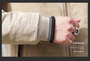 Detail display of beige jacket showing elastic knitted cuffs and gold metal zipper