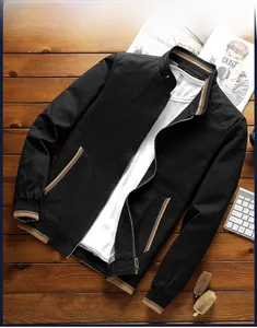 Detail view of black stand collar jacket with striped rib cuffs and hem on wooden background