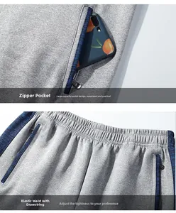 Detail of grey joggers with blue side stripes, elastic waistband and metal zipper pockets
