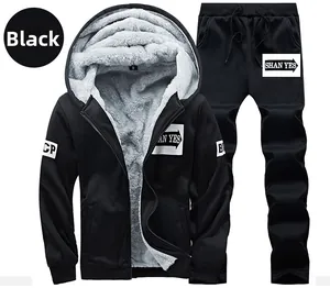 Detail view of black hooded tracksuit featuring thick grey faux fur lining and letter patches