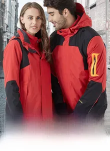 Outdoor couple wearing red and black waterproof jackets in a stylish city street setting