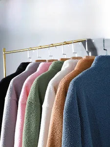 Selection of colorful teddy fleece jackets with high collar on golden hangers