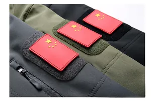 Detail der taktischen Jackenärmel mit Flaggen-Patches und verstellbarem Klettverschluss