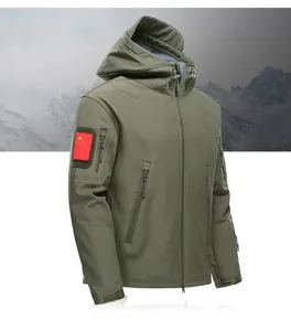 Armeegrüne taktische Softshelljacke mit Kapuze und mehreren Taschen vor verschneiten Bergen