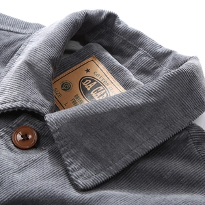 Close-up of a men's charcoal grey corduroy jacket with retro collar and brown buttons