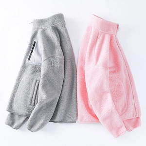 Detailed close-up of teddy fleece texture on gray and pink zip-up standing collar jackets