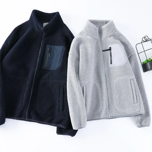 Detail of teddy fleece jackets showing stand collar and contrasting chest zipper pocket