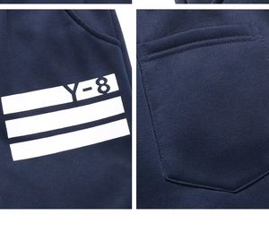 Macro view of navy blue jogger pants featuring white Y-8 print and side pocket detail