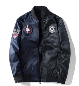 Dettaglio ravvicinato della giacca bomber blu navy con ricami e finiture a coste elastiche