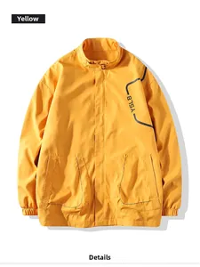 Close-up of bright yellow men's windbreaker featuring a stand collar and elastic cuffs