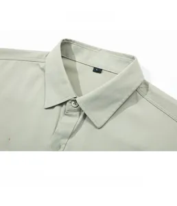 Close-up of light green shirt collar with neat stitching and rainbow stripe embroidery