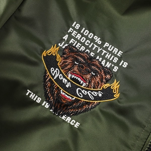 Détail de la broderie tête d'ours et du slogan sur le blouson aviateur vert olive