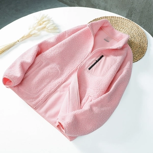 Pink teddy fleece jacket with stand collar and zipper pocket on white table