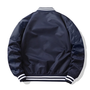 Rear view of navy blue bomber jacket showing windproof nylon fabric and striped ribbed hem