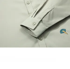 Detail of khaki twill shirt cuff with resin button and cloud lightning embroidery