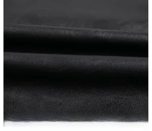 Detail showing high-quality black lychee texture faux leather fabric of a motorcycle jacket