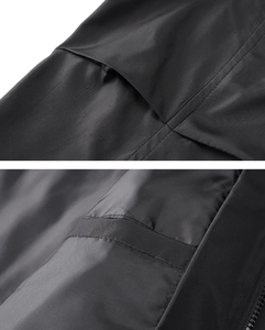 Detail view of the black jacket's functional pockets and reinforced stitching quality
