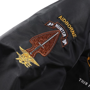 Gros plan sur l'écusson militaire brodé sur la manche d'un blouson aviateur noir texturé